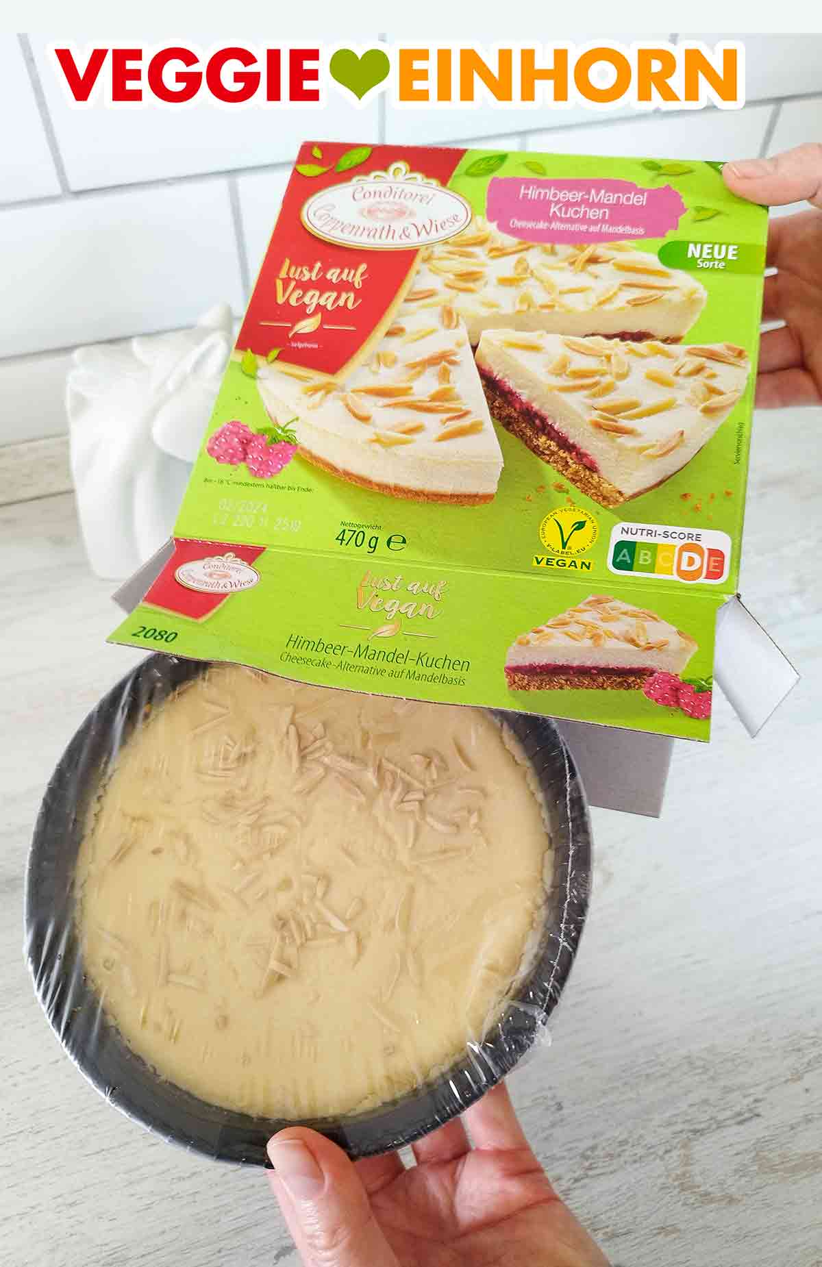 Der vegane Himbeer-Mandel-Kuchen von Coppenrath und Wiese wird aus der Packung genommen. Auspacken des veganen Himbeer Mandel Cheesecakes aus der Conditorei Coppenrath und Wiese