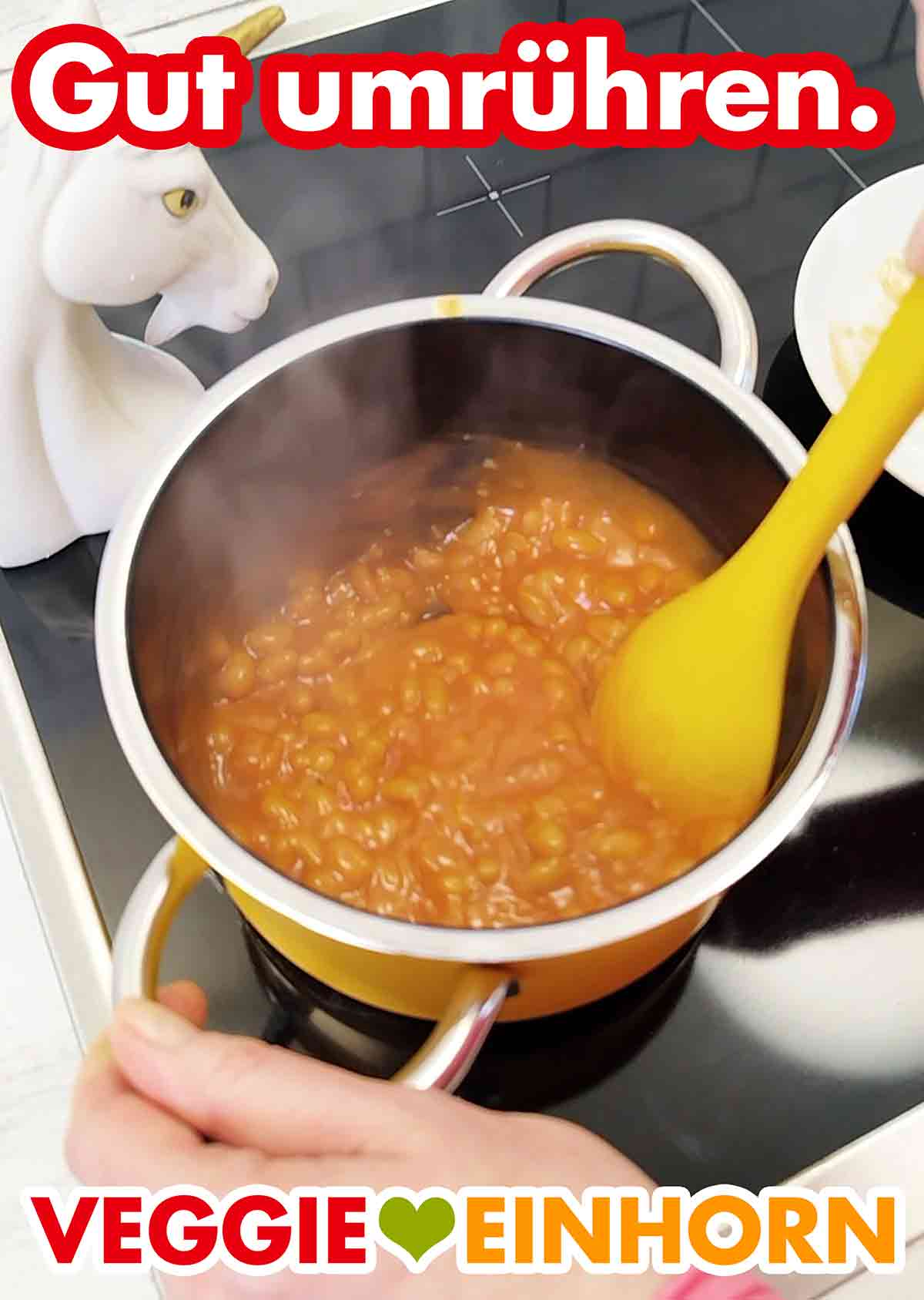 Umrühren der Baked Beans im Kochtopf Die Baked Beans werden im Topf umgerührt