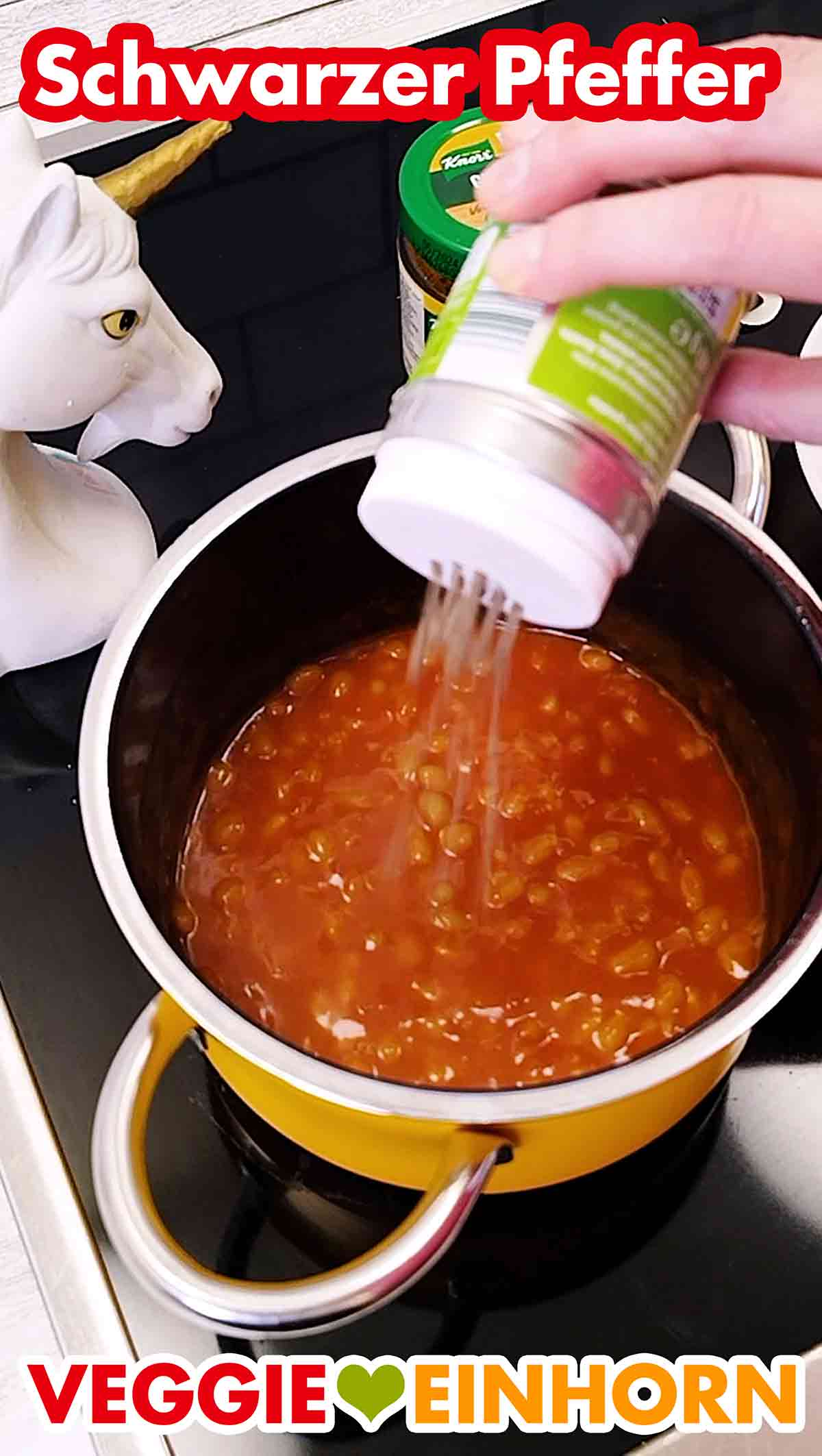 Die Baked Beans werden mit gemahlenem schwarzen Pfeffer gewürzt. Würzen der Baked Beans mit Pfeffer