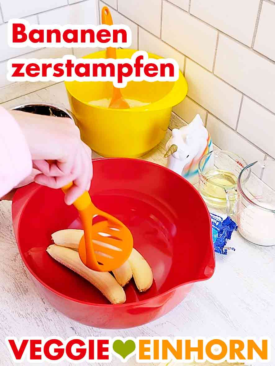 Du kannst die Bananen mit einem Kartoffelstamper oder mit einer Gabel zerdrücken. Ein Kartoffelstampfer und drei Bananen in einer Rührschüssel