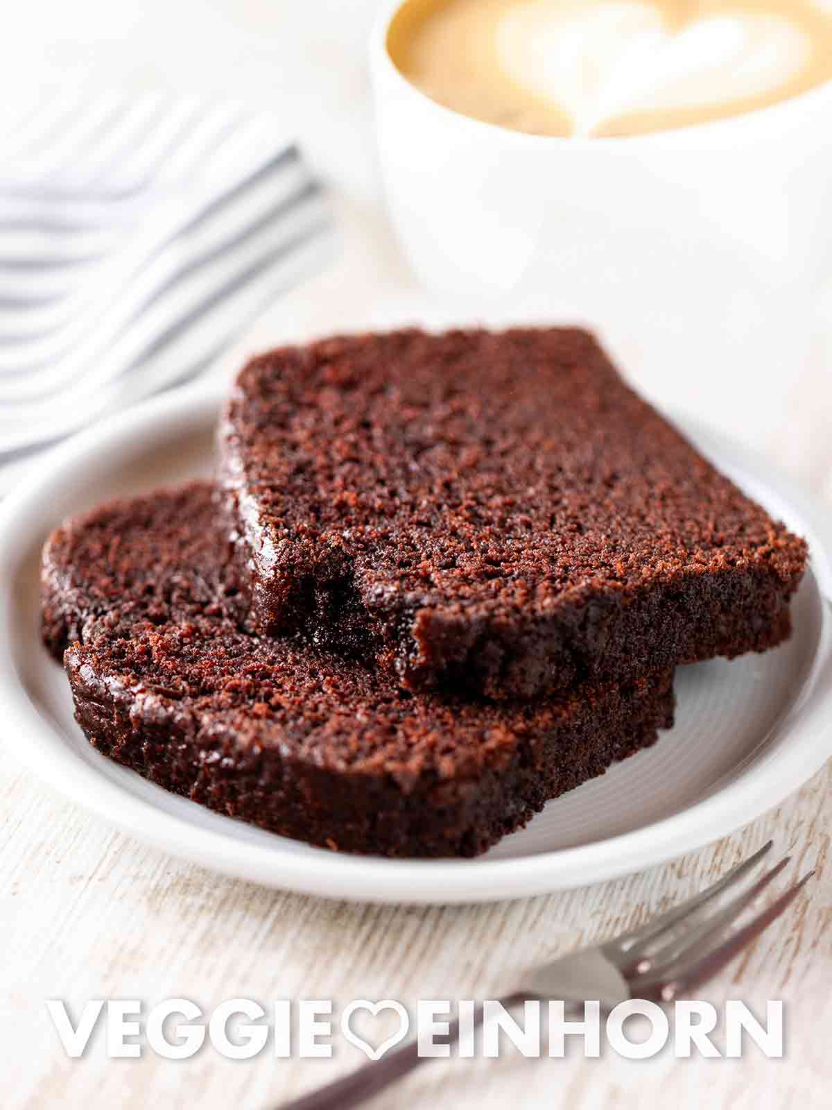 Ein schneller veganer Schokokuchen aus einfachem Rührteig ohne Ei und ohne Milch. Der beste vegane Schokokuchen auf einem Kuchenteller