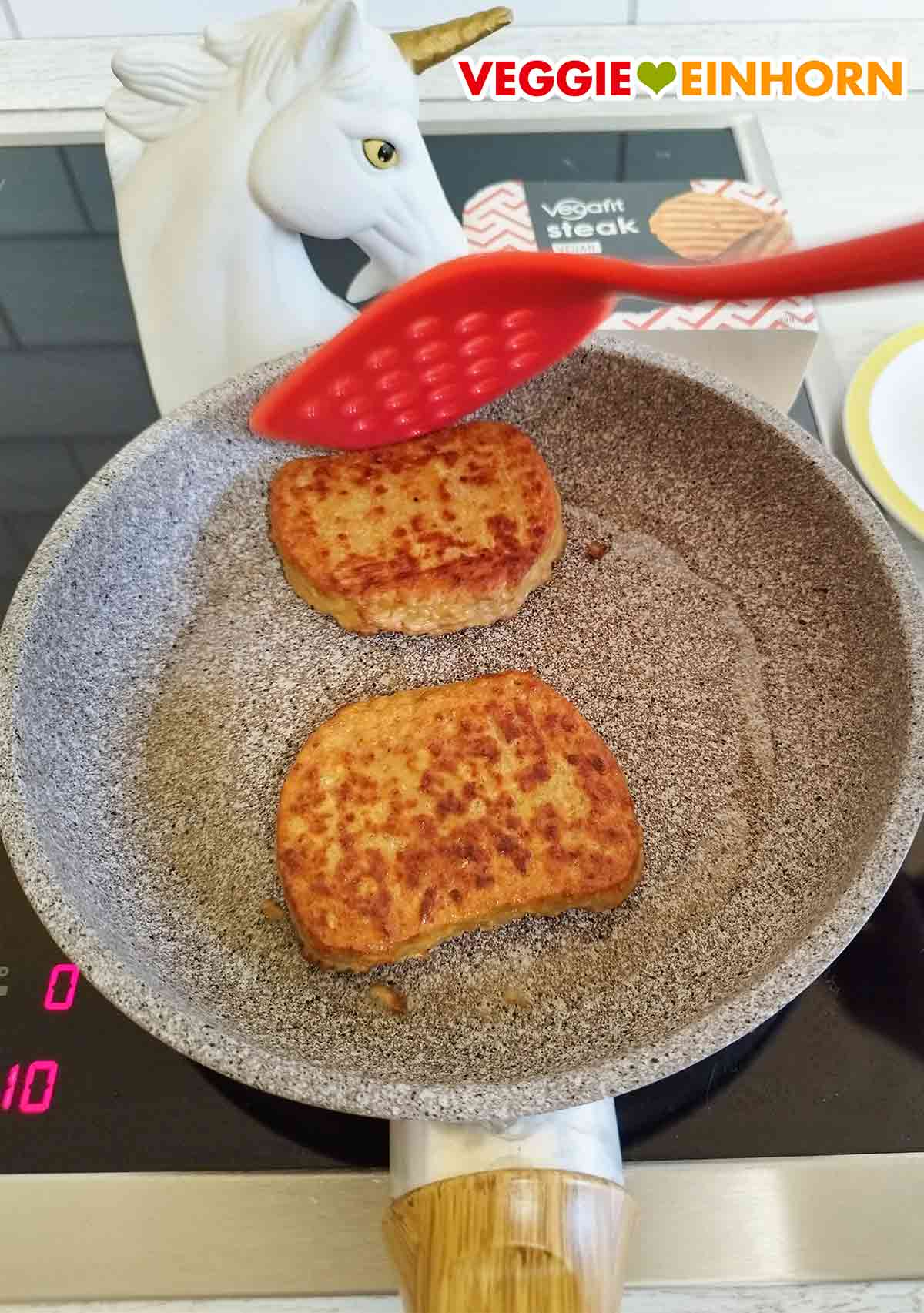 Die Unterseite der veganen Vegafit Steaks hat keine Grilllinien. Zwei Vegafit Steaks in der Pfanne nach dem Wenden