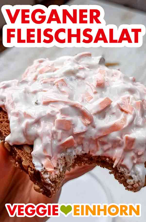 Leckerer veganer Fleischsalat mit veganer Wurst, veganer Mayonnaise und Gurken. Angebissene Brotscheibe mit veganem Fleischsalat von Popp Feinkost
