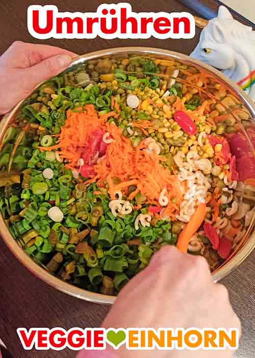 Den bunten Nudelsalat umrühren. Nudelsalat umrühren