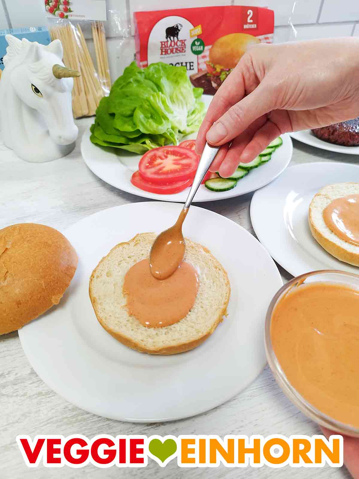 Veganes Burgerbrötchen mit veganer Bürgersoße Selbstgemachte vegane Burgersauce wird auf einen veganen Brioche Bun von Block House gegeben
