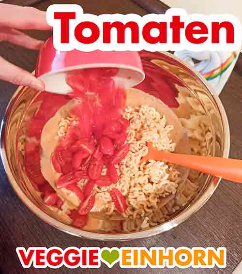 Geviertelte Cocktailtomaten zum Nudelsalat zufügen. Cherrytomaten