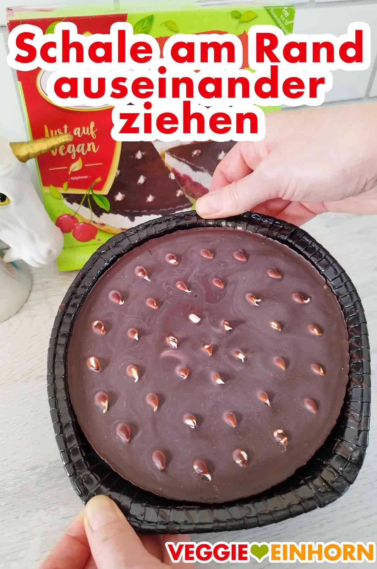 Auseinander ziehen der Schale, damit sich die tiefgekühlte vegane Donauwelle besser löst. Die Schale wird am Rand etwas auseinander gezogen.