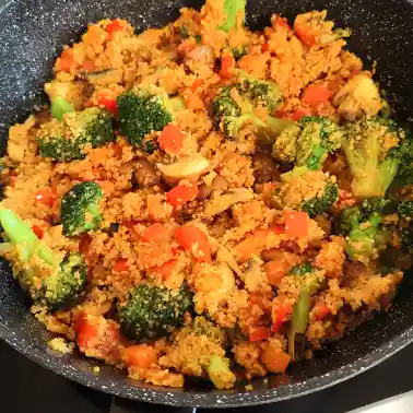 Couscous Pfanne mit Gemüse, darunter Brokkoli, Champignons, Möhren und Paprika.