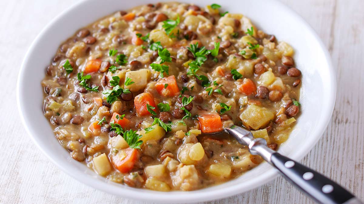 Der Linseneintopf mit Suppengrün und veganer Crème fraîche ist vegetarisch und vegan. Cremige Linsensuppe mit roten und braunen Linsen