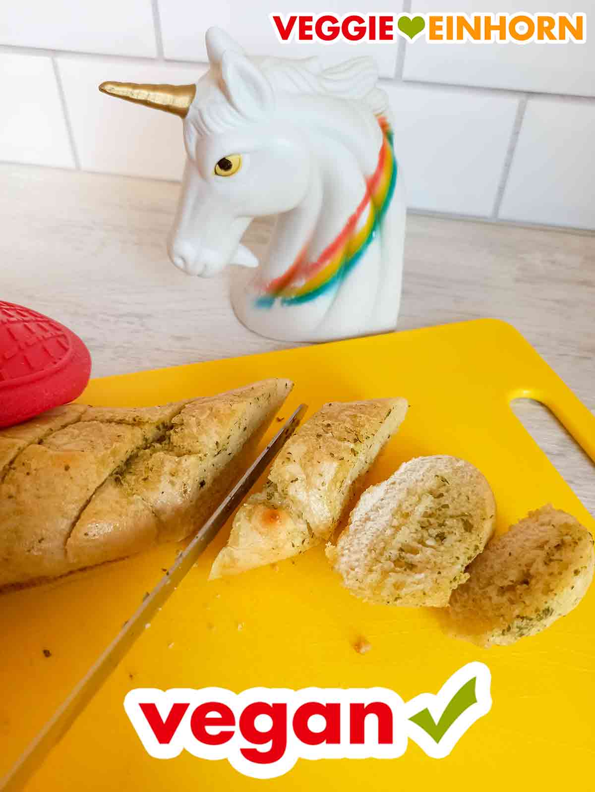 Das vegane Kräuterbaguette von Penny wird in Scheiben geschnitten. Schneiden des veganen Kräuterbaguettes von Food for Future mit einem Messer