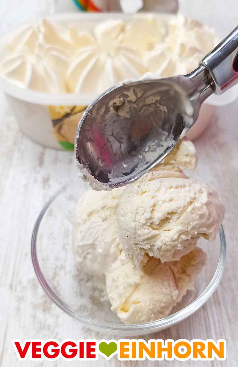 Das vegane Vanilleeis wird serviert. Vanilleeiscreme wird mit einem Eisportionierer in eine Dessertschale gegeben