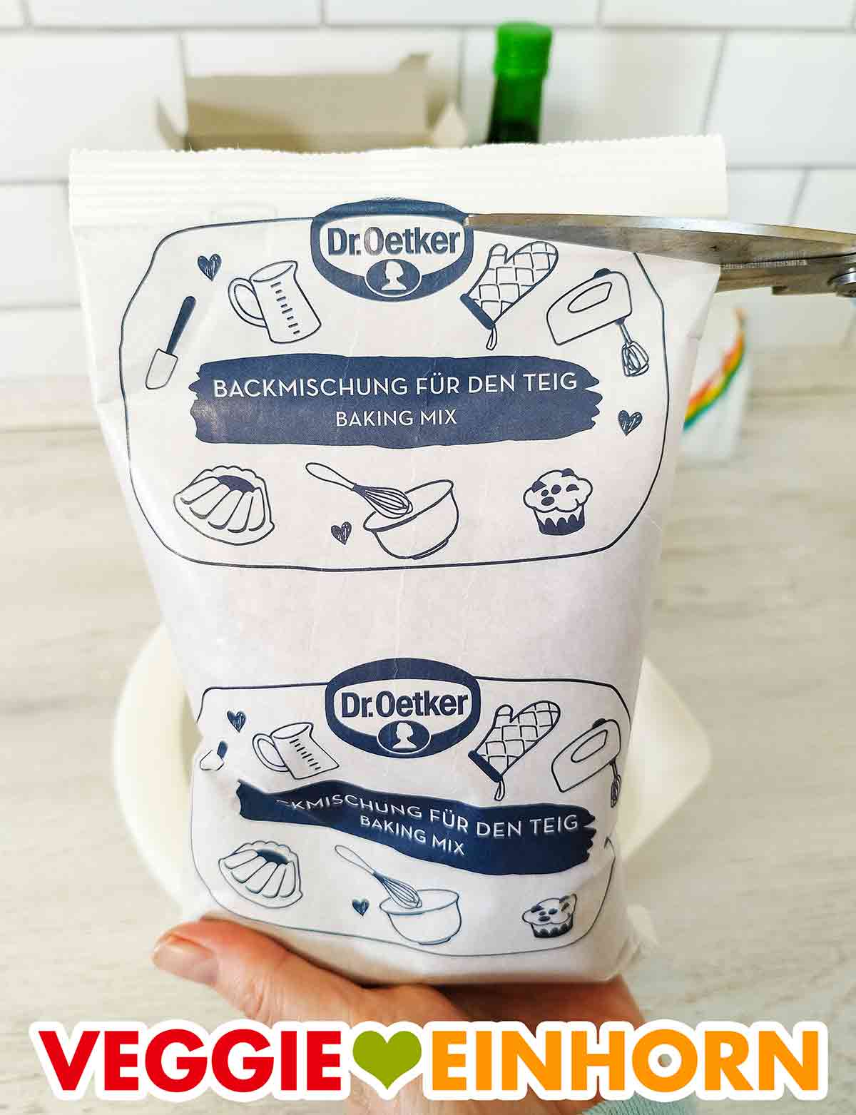 Öffnen der Tüte mit der veganen Brownie Backmischung von Dr. Oetker. Der Beuttel mit der veganen Brownie Backmischung wird mit einer Schere aufgeschnitten.