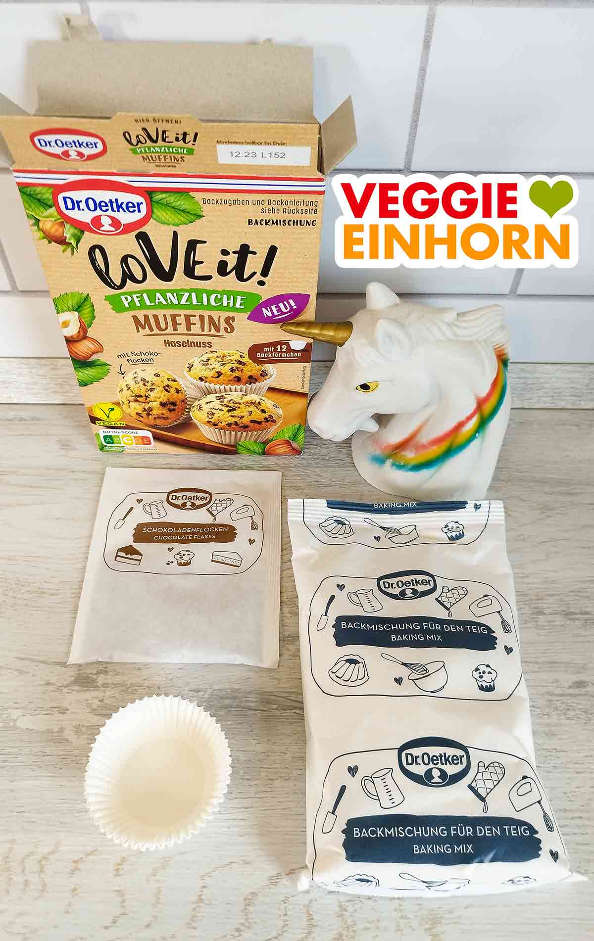 Die vegane Backmischung von Dr. Oetker enthält einen Beutel mit Schokoladenflocken, einen Beutel mit Backmischung für den Teig und 12 Muffinförmchen aus Papier. Schokoladenflocken, Backmischung für den Teig und Papier-Muffinformen aus der veganen Backmischung von Dr. Oetker.