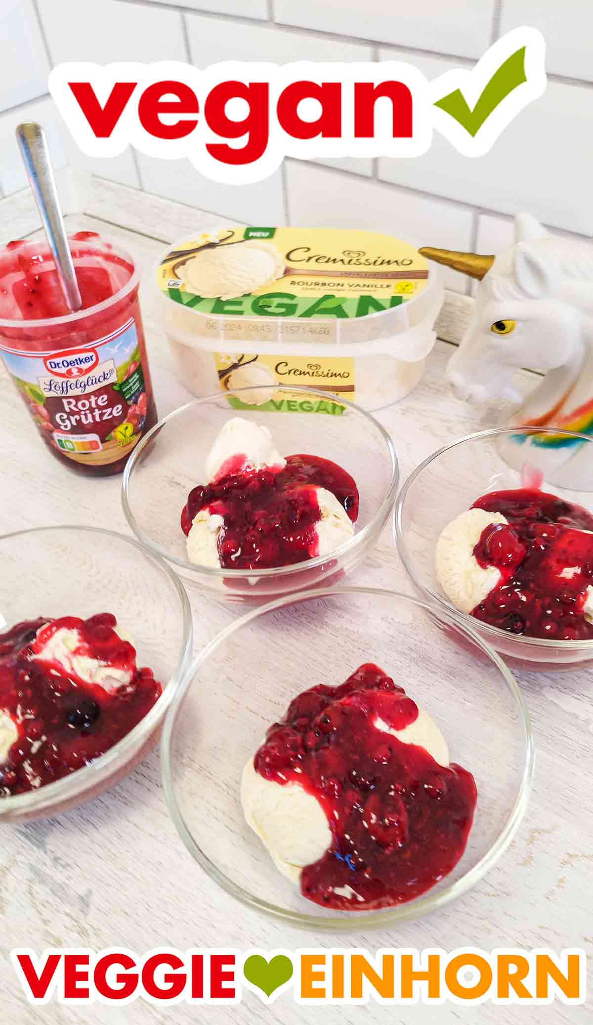 Die rote Grütze von Dr. Oetker wird mit veganem Vanilleeis von Cremissimo serviert. Vier Dessertschalen mit veganem Vanilleeis und roter Grütze