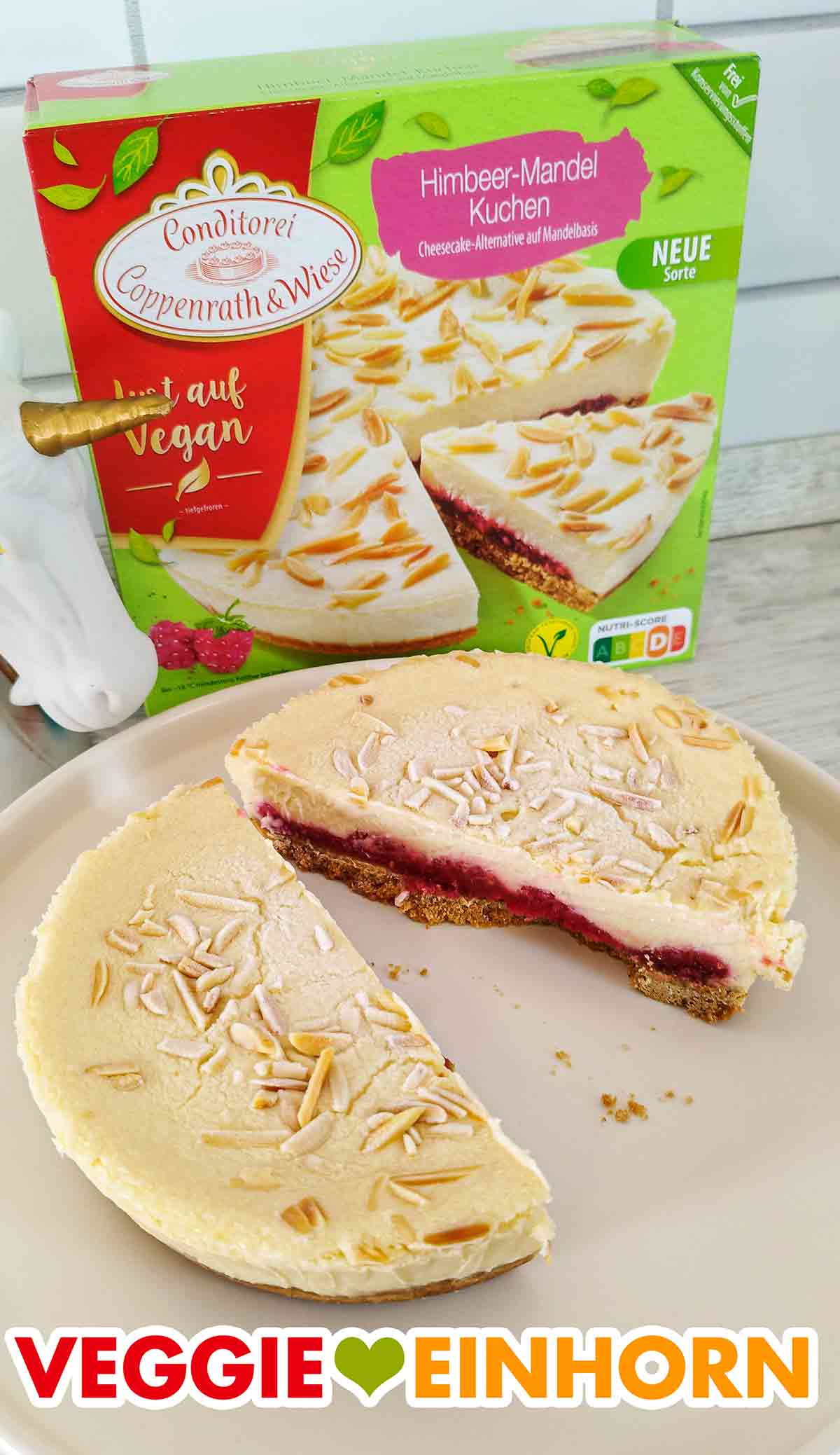 Der vegane Himbeer-Mandel-Kuchen von Coppenrath und Wiese ist in der Mitte durchgeschnitten. Halbierter veganer Himbeer Mandel Cheesecake von Coppenrath und Wiese