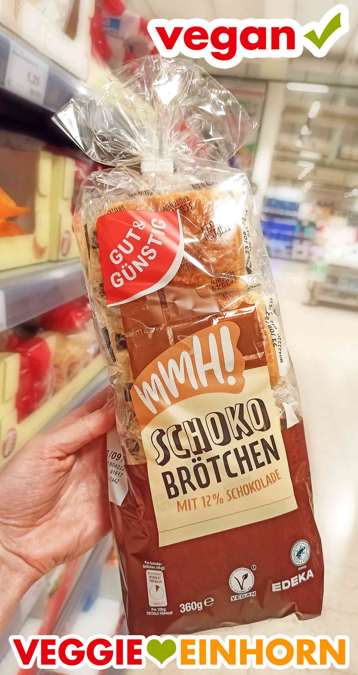 Auf der Packung ist ein Vegan Zeichen. Eine Hand hält eine Packung vegane Schokobrötchen von Edeka