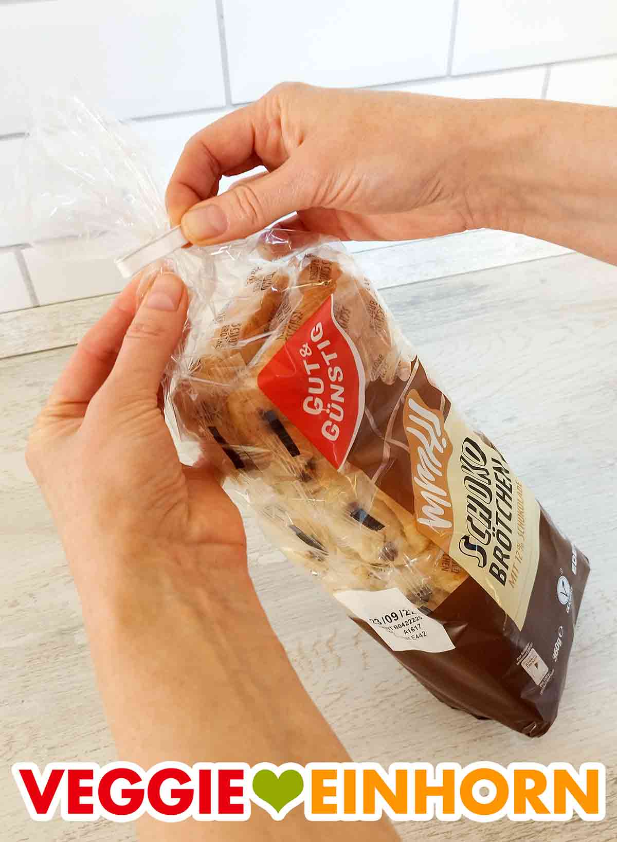 Ich öffne die Tüte mit den veganen Schokobrötchen von Gut und Günstig. Öffnen der veganen Schokobrötchen von Edeka