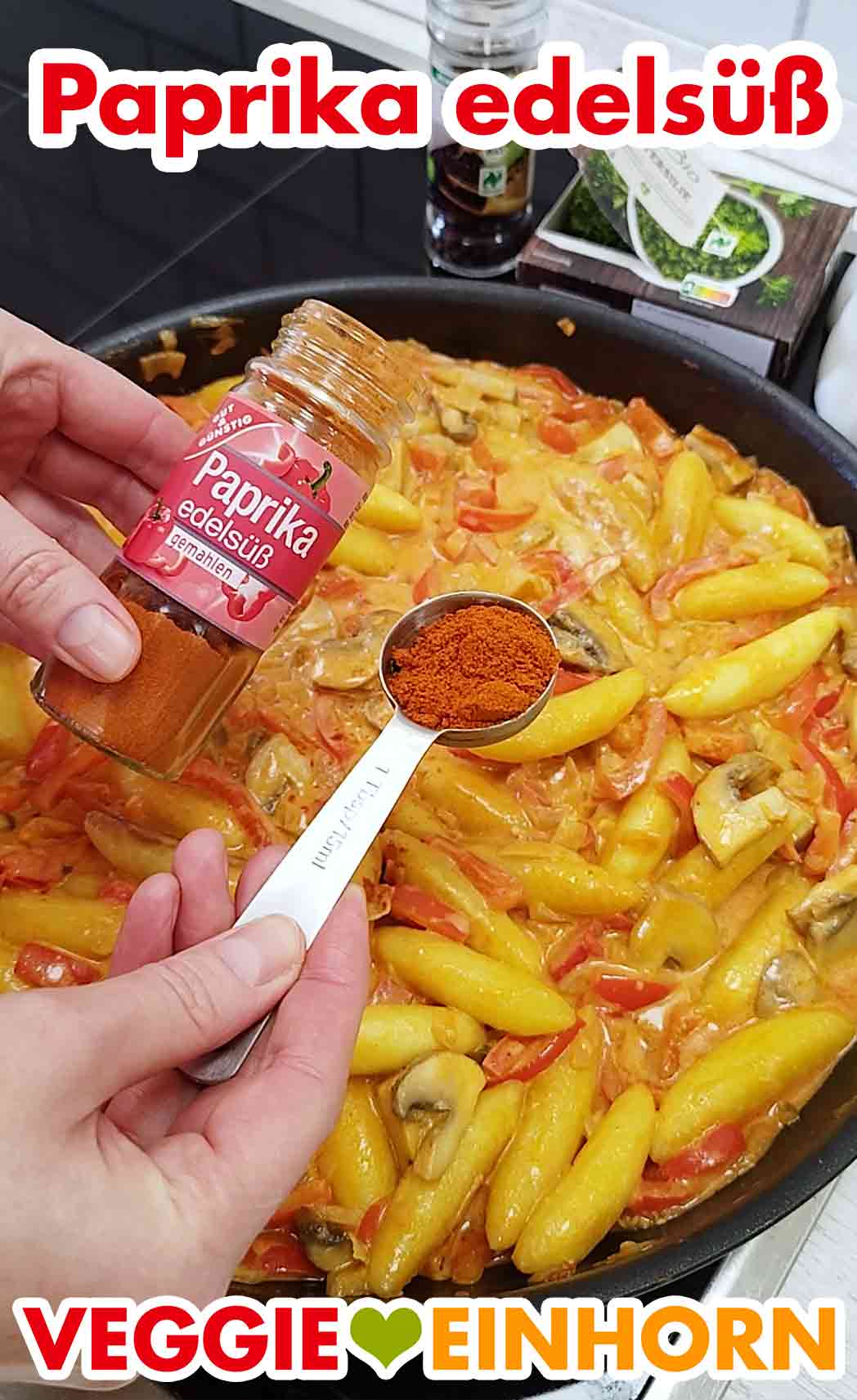 Würzen der Schupfnudelpfanne mit Paprika edelsüß. Ein Esslöffel Paprika edelsüß Pulver wird zugefügt