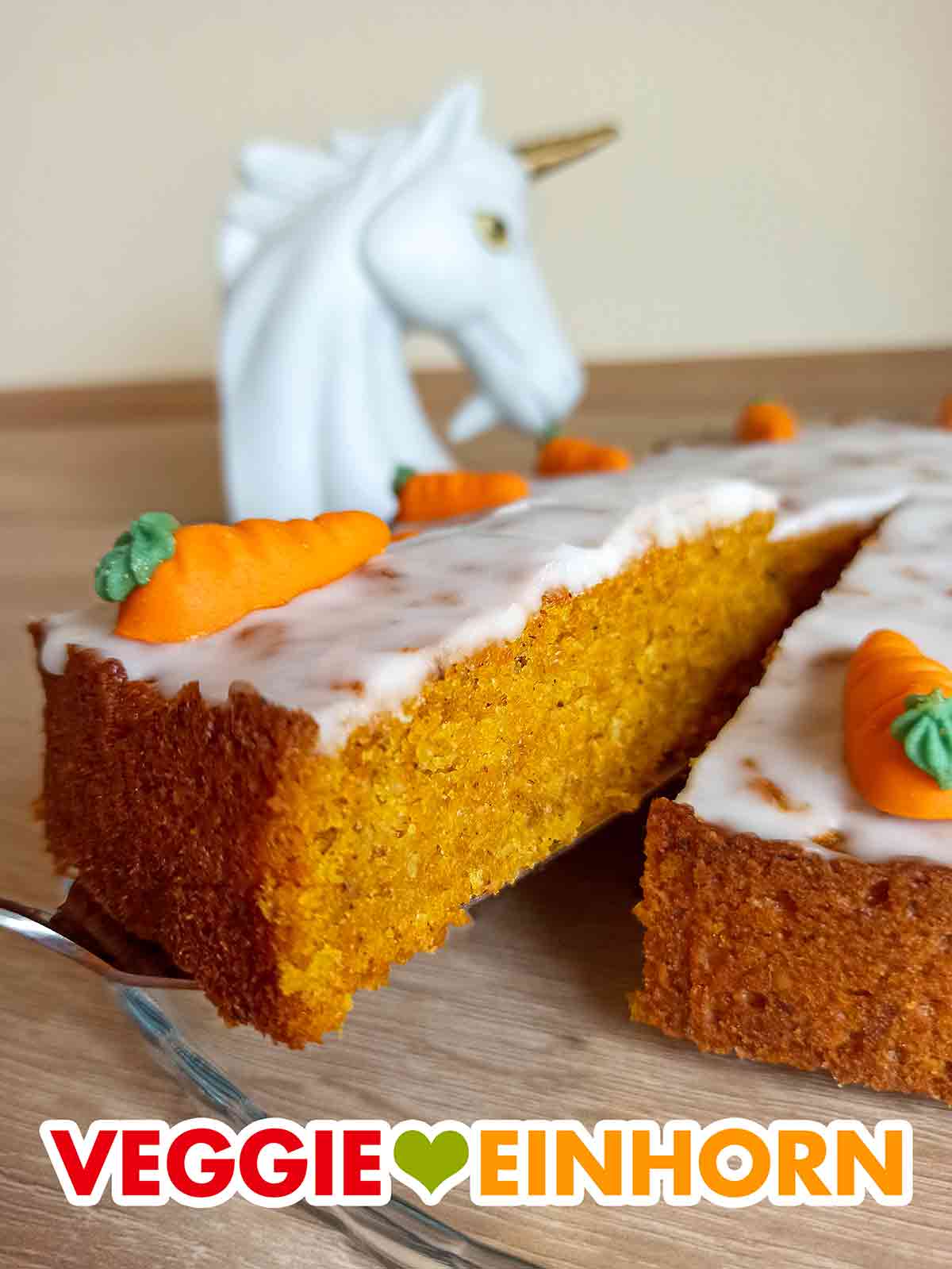 Der vegane Karottenkuchen mit Nüssen und Apfelmus sieht sehr saftig aus. Ein Stück veganer Karottenkuchen auf einem Kuchenheber