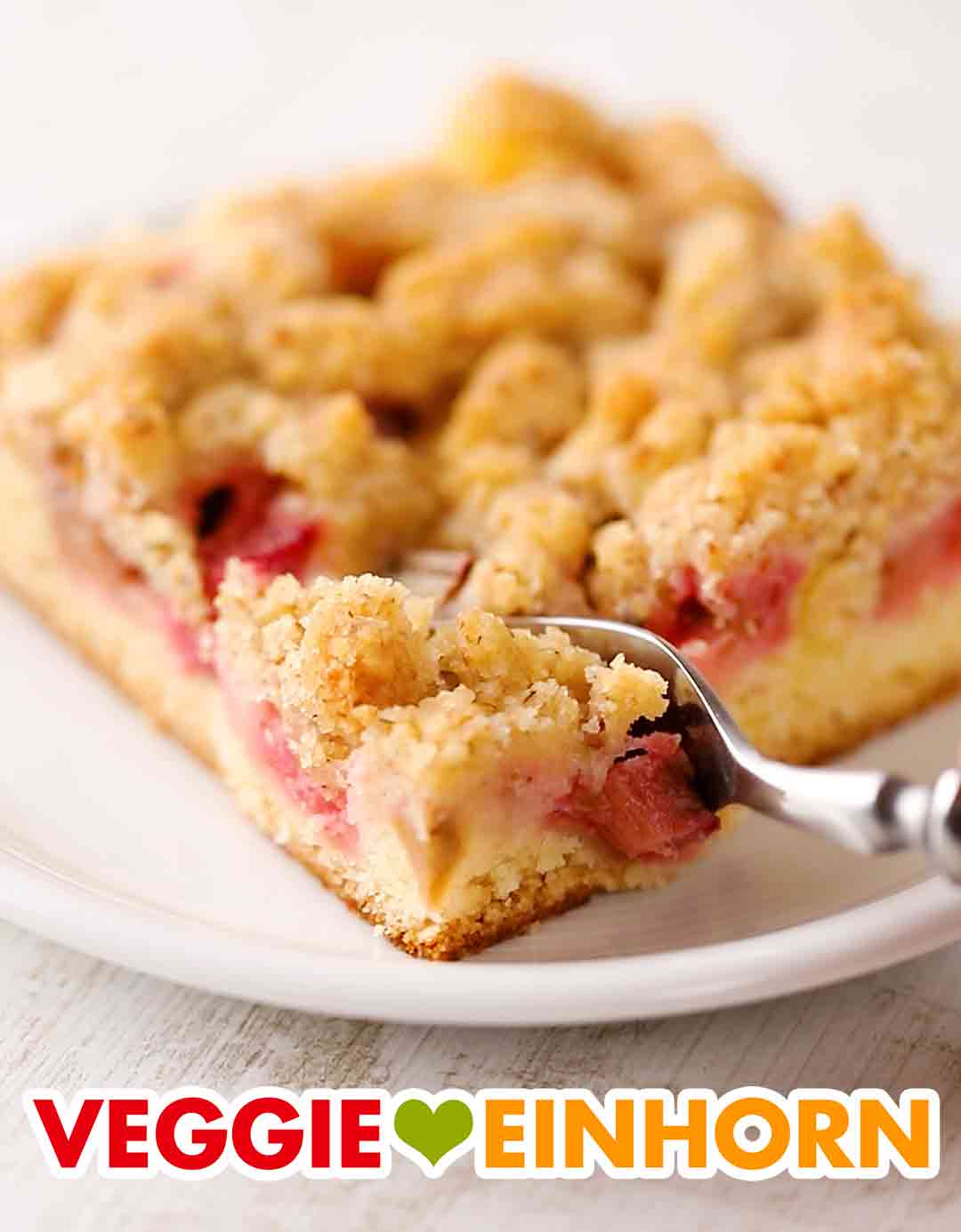 Der vegane Rhabarber Blechkuchen mit Streuseln ist saftig und lecker. Kuchenteller mit einem Stück veganem Streuselkuchen vom Blech mit Rhabarber
