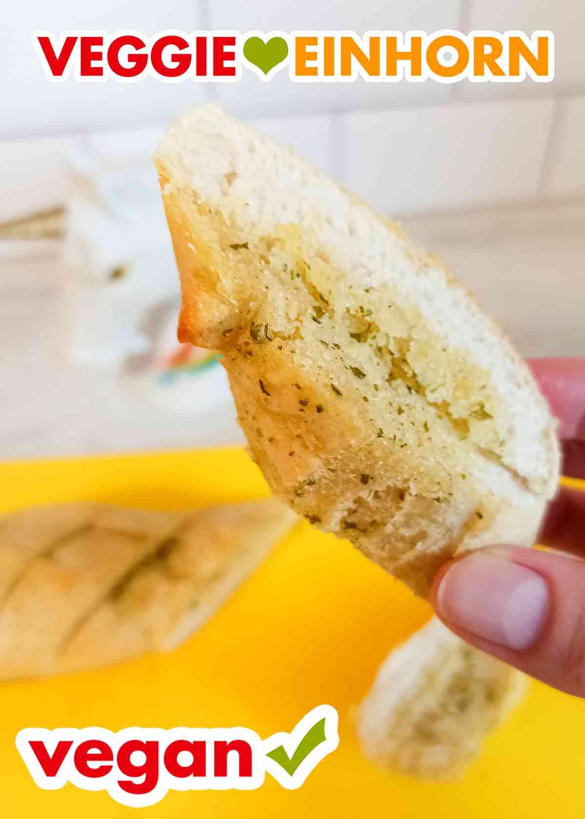 Ein Stück veganes Kräuterbaguette von Penny Food for Future Eine Hand hält eine Scheibe veganes Kräuterbaguette von Penny