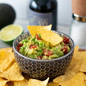 Einfache Guacamole mit Tomaten, serviert mit Tortilla Chips