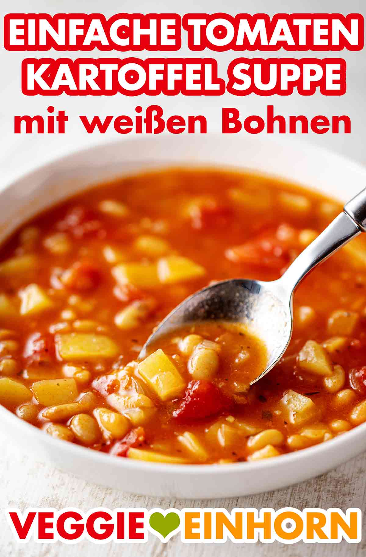 Die Suppe ist einfach, schnell und preiswert. Ein Esslöffel in einem Teller mit Tomaten Kartoffel Suppe mit weißen Bohnen