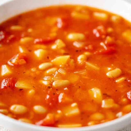 Teller mit Tomaten Kartoffel Suppe mit weißen Bohnen
