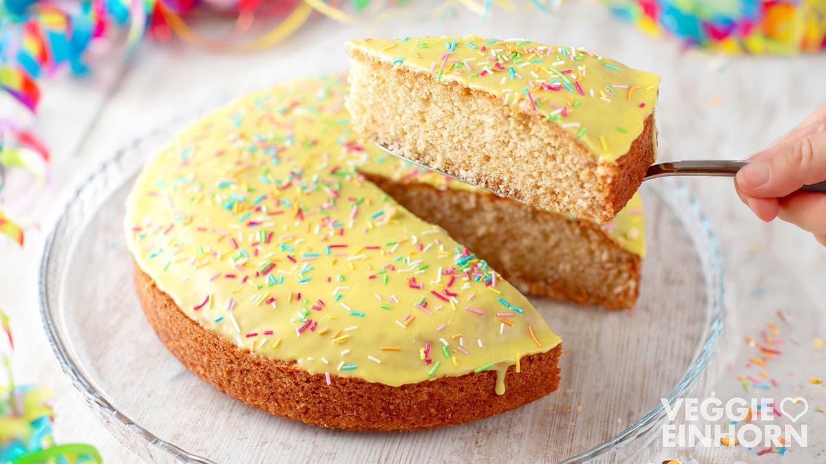 Der vegane Fantakuchen aus der Springform ist mit Öl und herrlich saftig, Runder veganer Fantakuchen auf einer Kuchenplatte