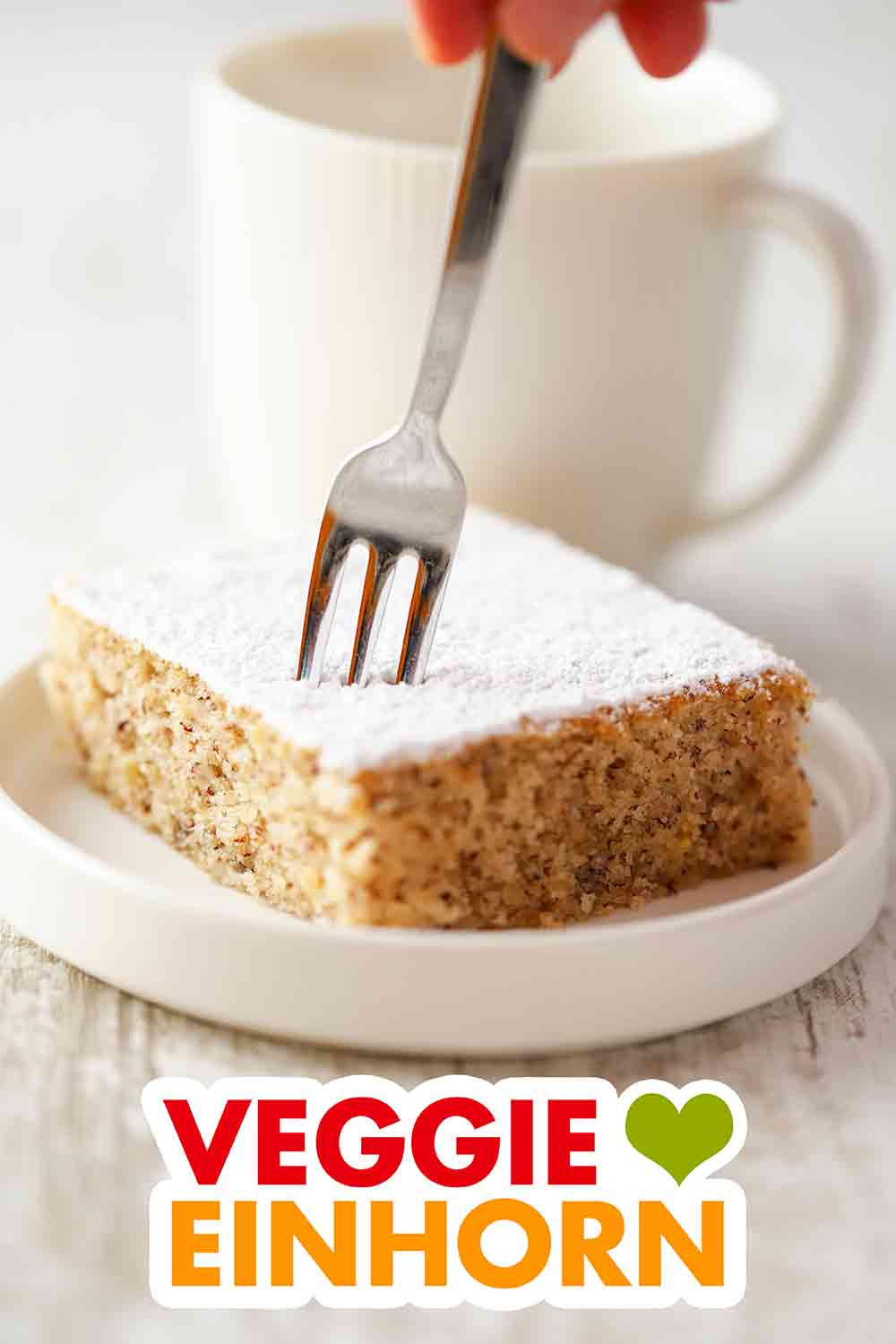 Der Blechkuchen mit Nüssen ist vegan. Ein Stück veganer Nuss Blechkuchen und eine Kuchengabel