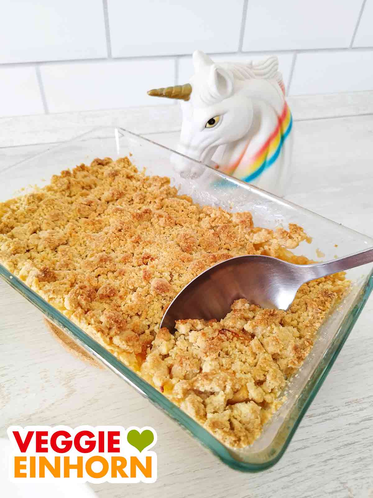 Der vegane Apple Crumble ist ein beliebter Nachtisch für Gäste. Veganer Apfel Crumble in einer kleinen Auflaufform aus Glas