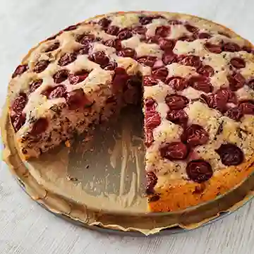 Aufgeschnittener veganer Kirschkuchen mit Schokolade aus der runden Springform.