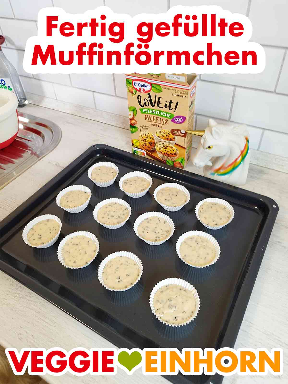 Die veganen Muffins aus der Dr. Oetker Backmischung sind fertig vorbereitet zum Backen. 12 mit Muffinteig gefüllte Förmchen auf dem Backblech