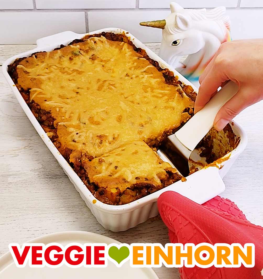 Die vegane Linsen Lasagne ist schön überbacken mit veganem Käse. Auflaufform mit fertig gebackener veganer Linsenlasagne mit Zucchini