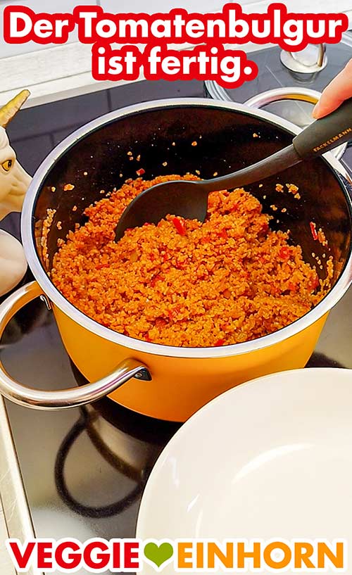 Der Tomaten Bulgur ist fertig gekocht. Servierlöffel im Topf mit dem fertigen Tomatenbulgur
