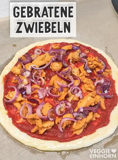 Pizza mit Tomatensauce und veganem Gyros, belegt mit gebratenen roten Zwiebelringen.