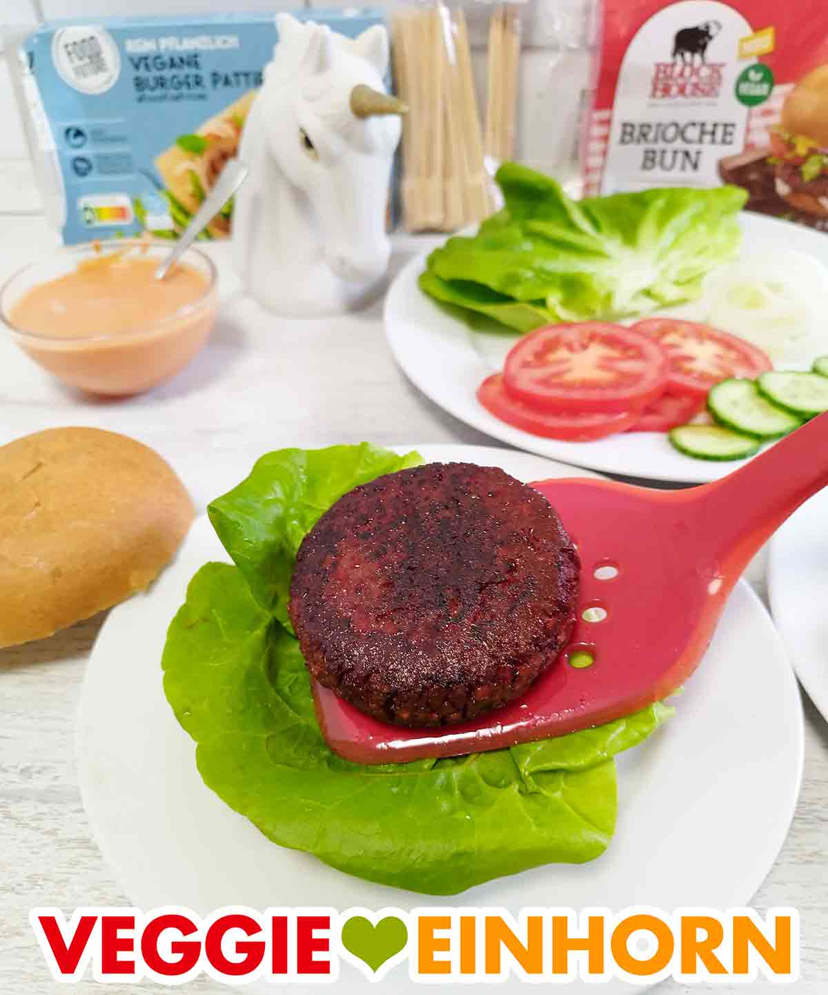 Unter den Patty liegt ein Salatblatt auf dem Burgerbrötchen. Der vegane Burger Patty von Penny wird auf den Burger gelegt