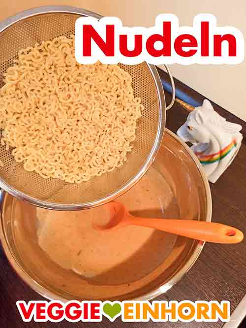 Die gekochten Nudeln zum Dressing zufügen. Die gekochten Nudeln werden zugefügt.