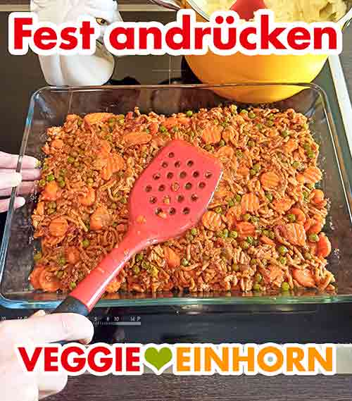 Die Mischung fest andrücken. Die vegane Gemüse-Hack-Masse wird mit einem Pfannenwender fest angedrückt.