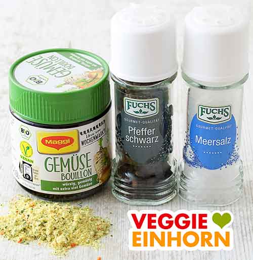 Maggi Bio Gemüsebouillon, Pfeffer und Meersalz Ein Glas Gemüsebrühe Pulver, eine Pfeffermühle und eine Salzmühle