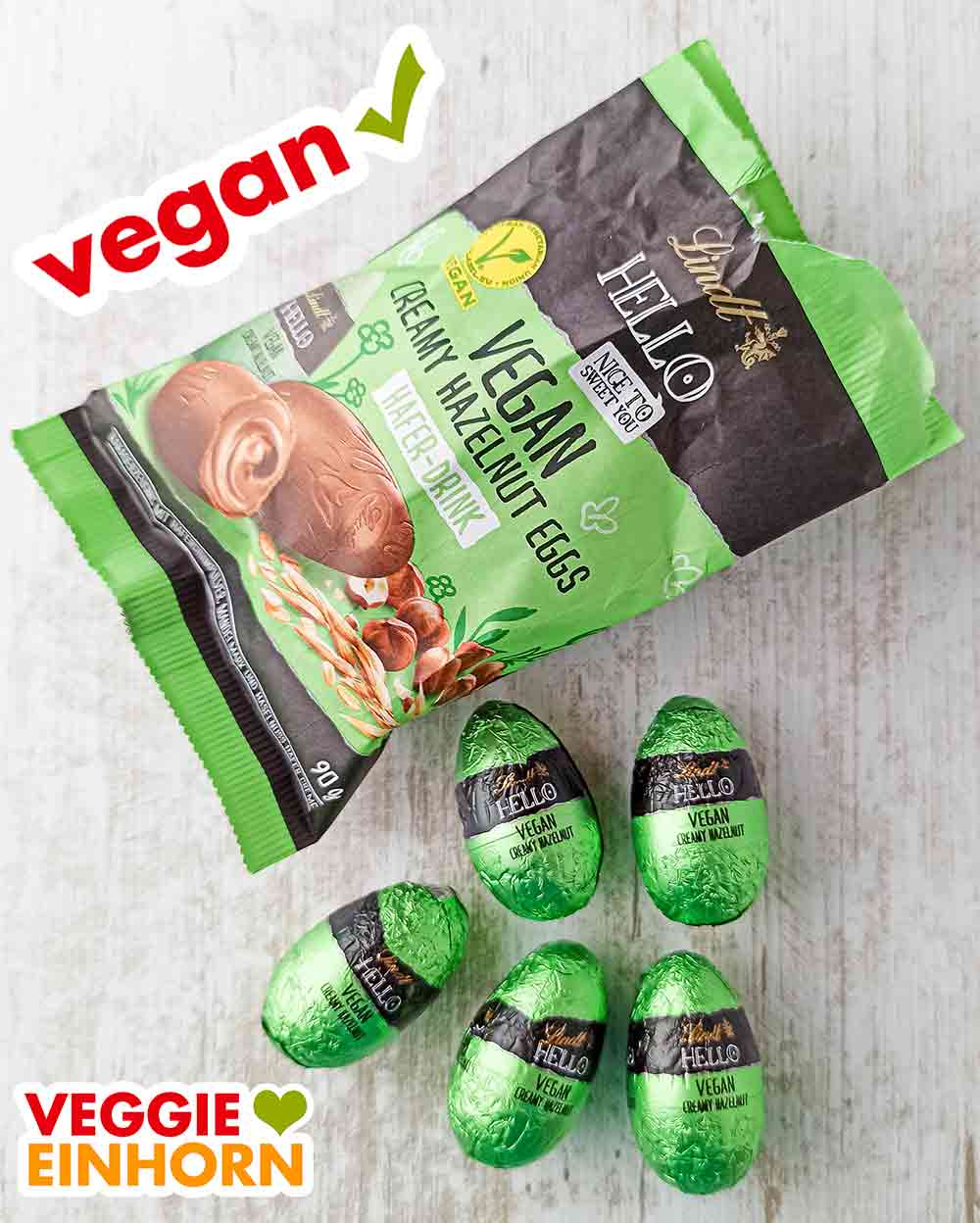 In der Tüte sind 5 gefüllte Schokoladeneier. Eine geöffnete Packung Lindt Hello Vegan Creamy Hazelnut Eggs und fünf Schokoeier