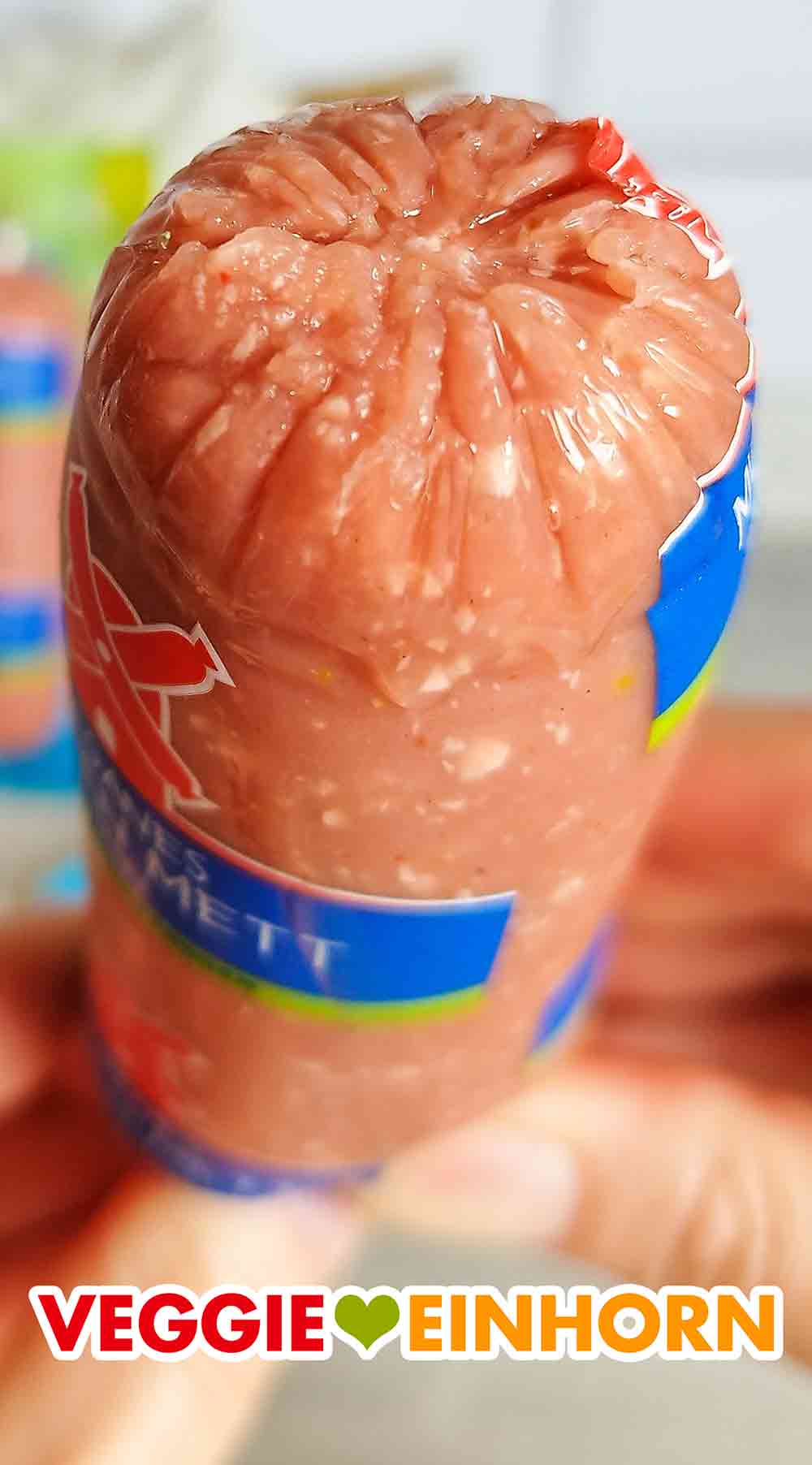 Das vegane Rügenwalder Mett ist hellrot und weiß. Geöffnete Wursthülle mit veganem Mühlen Mett Fein von Rügenwalder