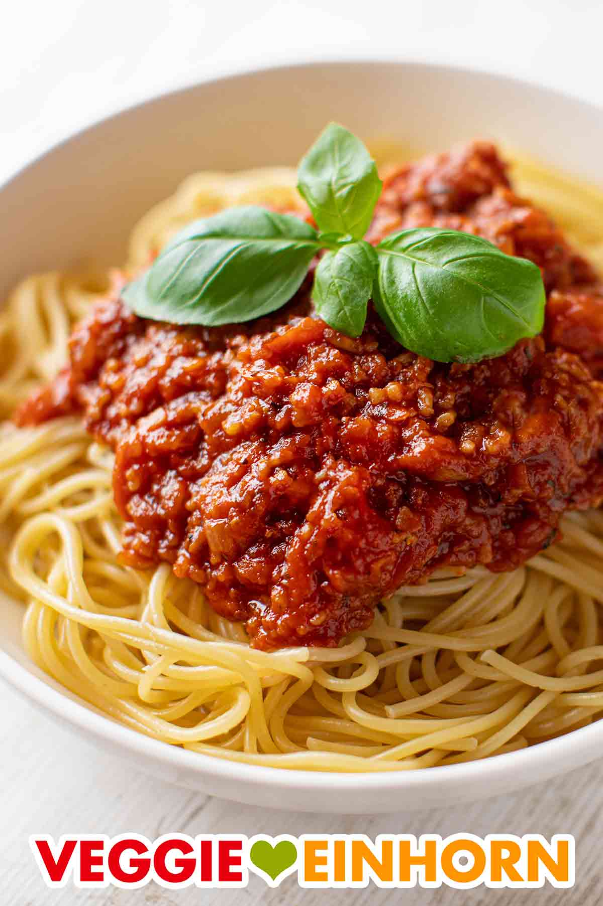 Vegane Grünkernbolognese auf einem Teller mit Nudeln. Spaghetti mit Grünkern Bolognese