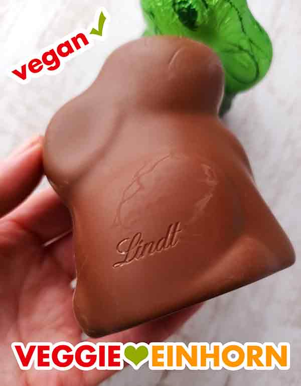 Auf der Seite des Schokohasen steht der Schriftzug Lindt. Der vegane Lindt Hello Hase von der Seite mit Schriftzug Lindt