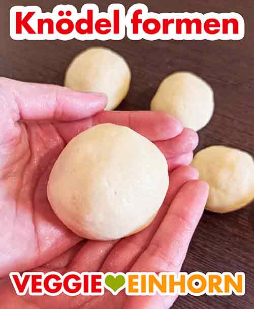 Den Teig mit feuchten Händen zu Knödeln formen Ein selbstgemachter Kartoffelkloß in der Hand