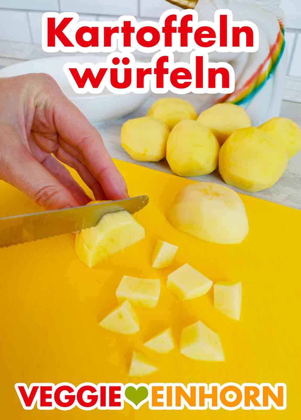 Die geschälte Kartoffel wird klein geschnitten. Eine Kartoffel wird auf einem Schneidebrett mit einem Messer in kleine Würfel geschnitten.