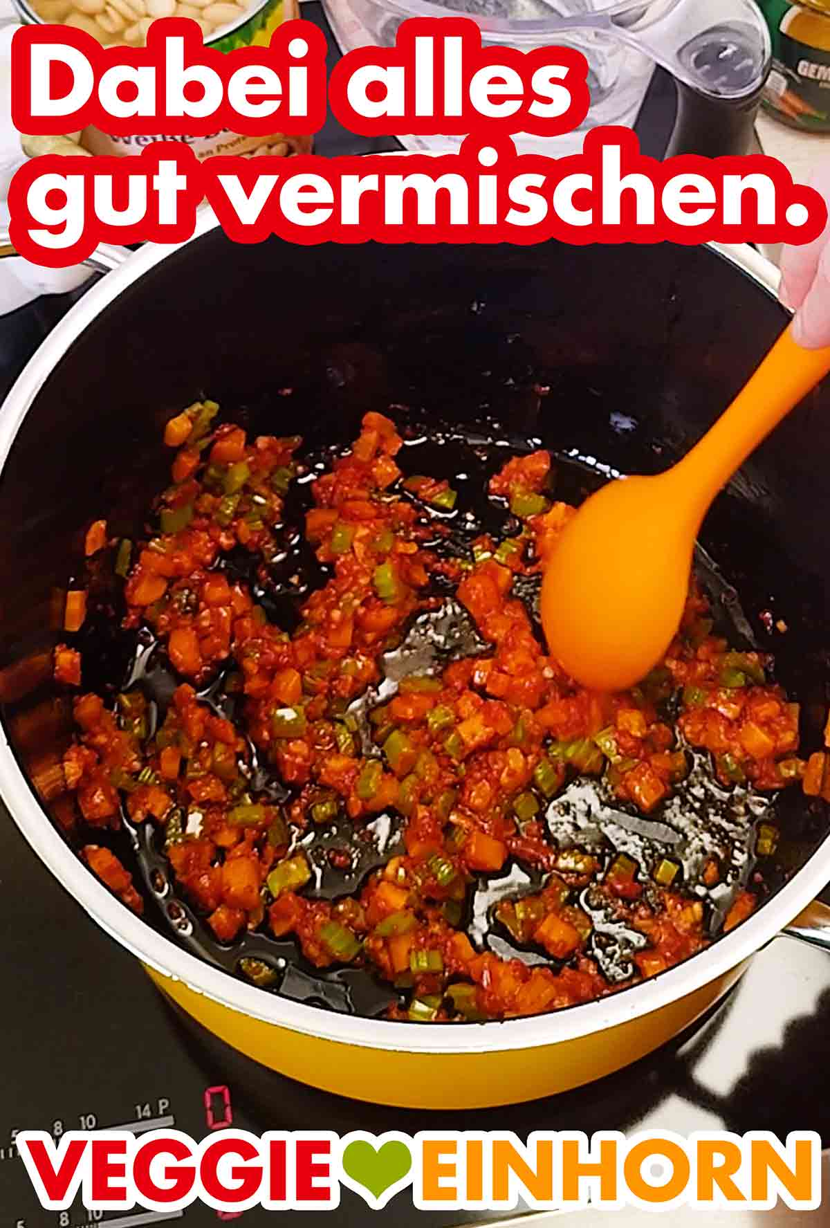 Möhre, Stangensellerie, Olivenöl, Tomatenmark und Knoblauch werden mit einem Kochlöffel gut umgerührt. Vermischen der Zutaten für Pasta e Fagioli
