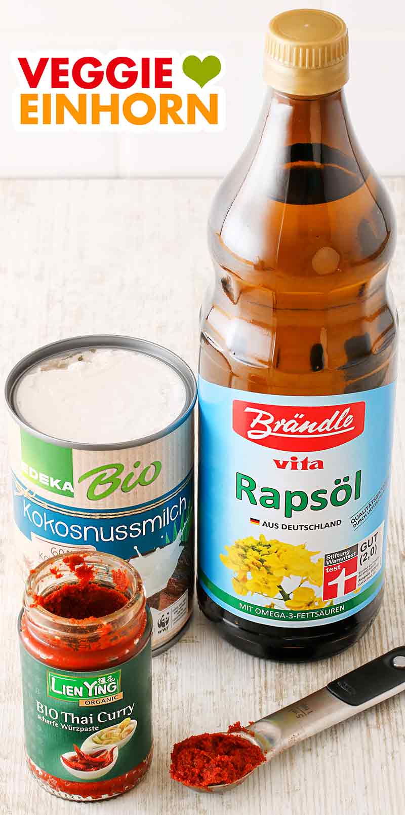 Edeka Bio Kokosnussmilch, Brändle vita Rapsöl und Lien Ying Currypaste Eine Dose Kokosmilch, eine Flasche Öl und ein Glas rote Thai Curry Paste
