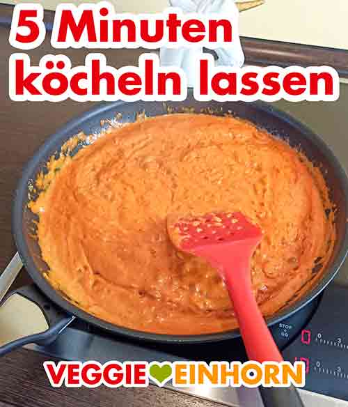 Vegane cremige Nudelsoße mit Tomatenmark und Kokosmilch Die Soße mit Kokosmilch und Tomatenmark kocht in der Pfanne.