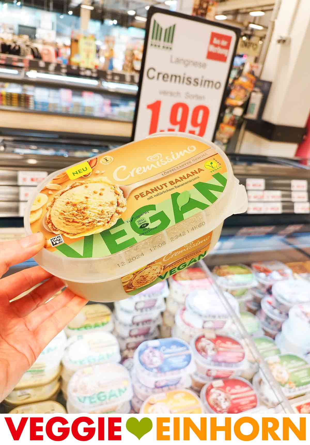 Veganes Cremissimo Peanut Banana in der Eisabteilung im Supermarkt Eine Hand hält eine Packung vegane Peanut Banana Eiscreme von Langnese Cremissimo.